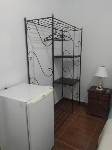 a room with a refrigerator and a shelf at Pousada Santo Expedito in Tiradentes