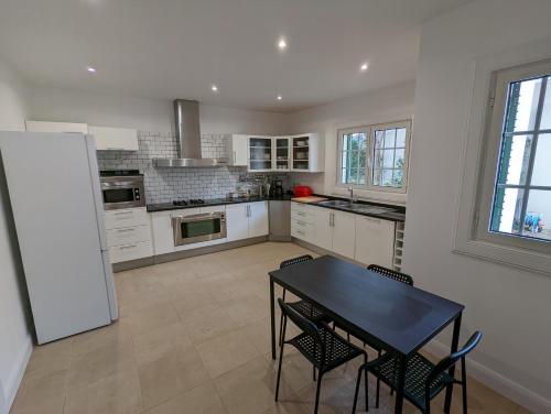 a kitchen with a black table and some chairs at Casa Roc Madeira - 5 Bedrooms - Ocean and City Views - Private Heated Pool in Funchal