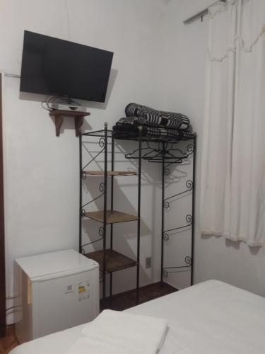 a bedroom with a television on top of a dresser at Pousada Santo Expedito in Tiradentes