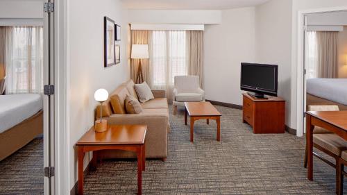 Cette chambre d'hôtel dispose d'un canapé et d'une télévision. dans l'établissement Residence Inn by Marriott Tucson Williams Centre, à Tucson