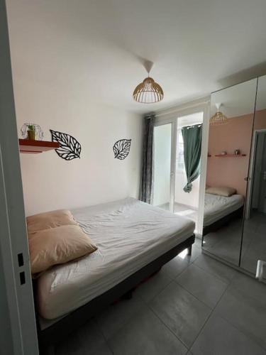 une chambre avec un lit et un miroir dans l'établissement Appartement 2 pièces, lumineux, avec parking, à Cabourg