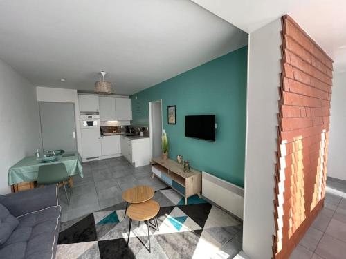 salon z kanapą i stołem w obiekcie Appartement 2 pièces, lumineux, avec parking w mieście Cabourg