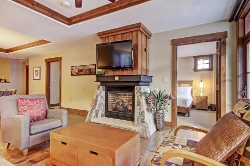 a living room with a fireplace with a tv above it at One Ski Hill Place S8309 in Breckenridge