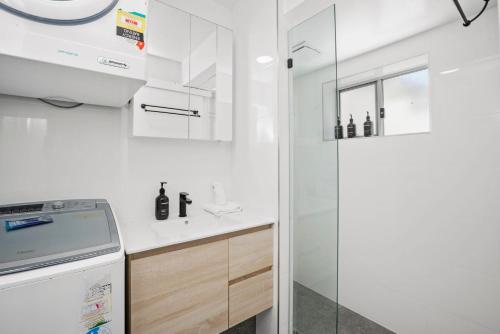 a white kitchen with a sink and a shower at Apartment 5B in Lennox Head