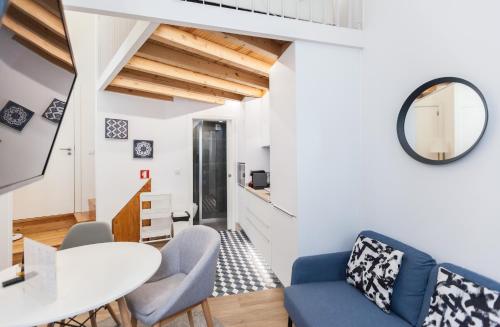 - un salon avec une table, des chaises et un miroir dans l'établissement FLH Graça Lovely Apartment IV, à Lisbonne