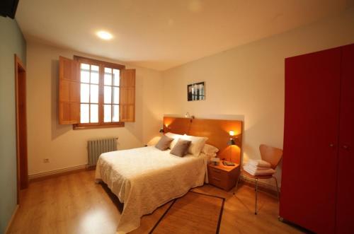 sypialnia z łóżkiem, krzesłem i oknem w obiekcie HOTEL PIORNEDO w mieście Lugo