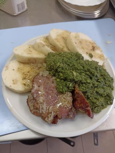 a plate of food with meat and vegetables and potatoes at Penzion U Halířů in Mladé Buky