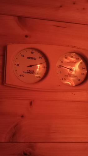 two temperature gauges on a wooden wall at Penzion U Halířů in Mladé Buky