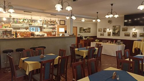 un restaurante con mesas y sillas y un bar en Penzion U Halířů en Mladé Buky