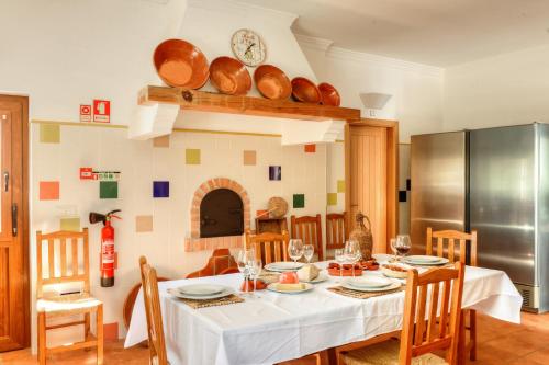 a kitchen and dining room with a table and chairs at Quinta dos Tesouros in São Brás de Alportel