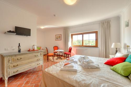 a bedroom with a bed and a table and chairs at Quinta dos Tesouros in São Brás de Alportel