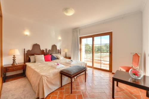 a bedroom with a large bed and a window at Quinta dos Tesouros in São Brás de Alportel