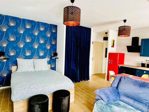 a bedroom with a bed and a blue wall at Merveilleux T2 en hypercentre in Châlons-en-Champagne