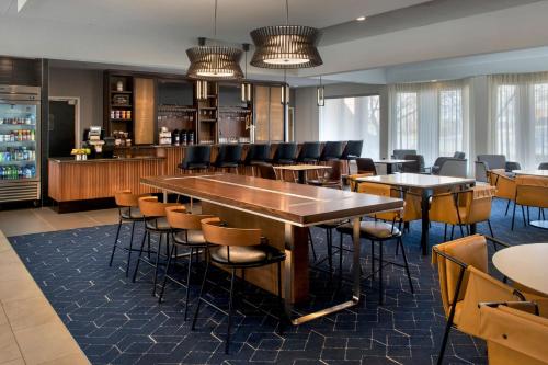 ハントバレーにあるCourtyard By Marriott Baltimore Hunt Valleyのテーブルと椅子のあるバーのあるレストラン