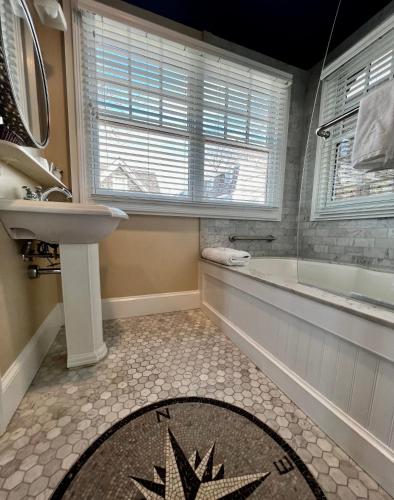 a bathroom with a bath tub and a sink and a bath tub at Almondy Inn Bed & Breakfast in Newport