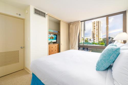 um quarto com uma cama branca e uma grande janela em Great Diamond Head Views, 2BR Condo with Free Parking! em Honolulu