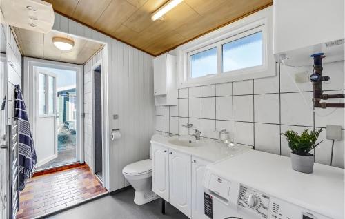 uma casa de banho branca com um WC e um lavatório em Beach Front Home In Rm With Wifi em Sønderby