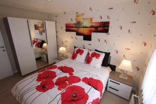 a bedroom with a bed with red flowers on it at Skyline in Ypres