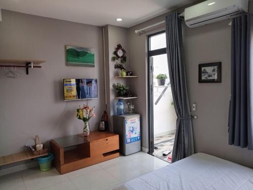 a bedroom with a refrigerator and a table and a window at A&H apartment, new, close to beach and market, in quite peaceful street in Nha Trang