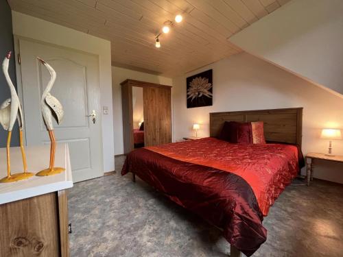 ビューリンゲンにあるApartment in Belgian Eifelのベッドルーム1室(赤いベッドカバー付きの大型ベッド1台付)