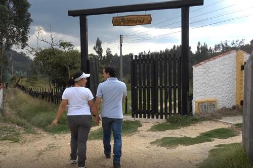 a man and a woman walking through a gate at Aldebarán Boyacá in Duitama