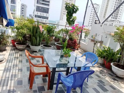 a glass table and chairs on a balcony with plants at A&H apartment, new, close to beach and market, in quite peaceful street in Nha Trang