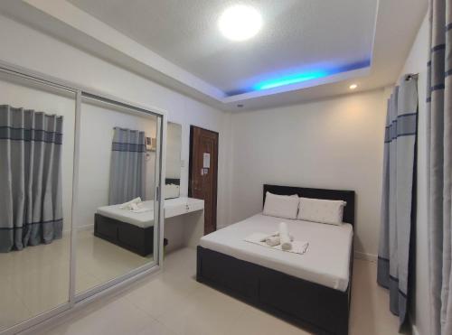 a bedroom with a bed and a sink and a mirror at Livewire Planet Suites in General Santos
