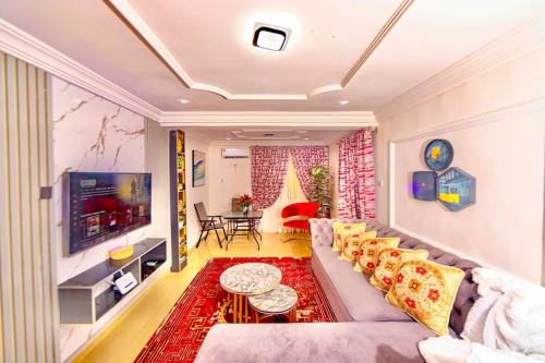 uma sala de estar com um sofá e uma televisão em Blaze by Treston Grand Apartment, Maitama em Abuja