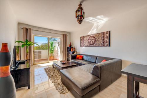 ein Wohnzimmer mit einem Sofa und einem Tisch in der Unterkunft AlgarSun - idealy situated holiday apartment with all modern comfort in Albufeira