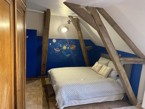 ein Schlafzimmer mit einem Bett mit einem Holzrahmen in der Unterkunft Gite La famille est dans les blés in Brinay