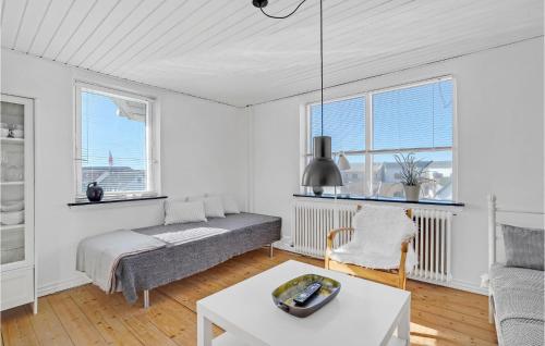 uma sala de estar branca com uma cama e uma mesa em Beautiful Apartment In Hirtshals With Kitchen em Hirtshals