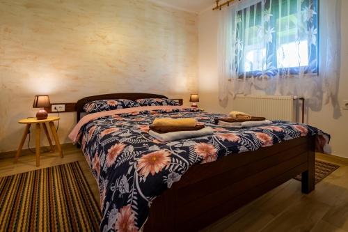 a bedroom with a bed with a floral bedspread at Holiday house with a parking space Sleme Skradsko, Gorski kotar - 20726 in Skrad