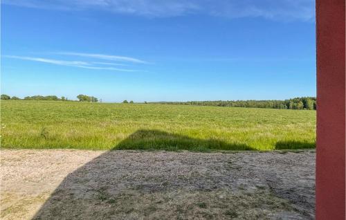 a large field of grass with a shadow on the ground at Amazing Apartment In Østermarie in Østermarie