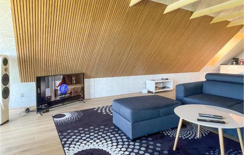 a living room with a couch and a tv at Amazing Apartment In Østermarie in Østermarie