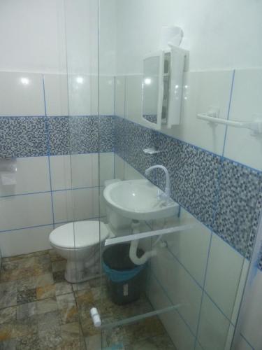y baño con aseo y lavamanos. en Angra Suítes em Família en Angra dos Reis