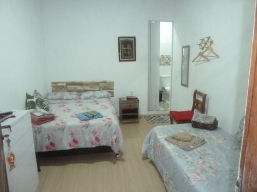 a bedroom with two beds and a mirror at Angra Suítes em Família in Angra dos Reis