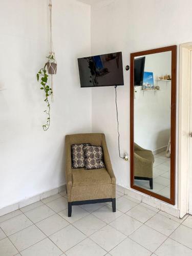 a chair in a room with a mirror and a tv at Rincón Caribeño - Amplio estudio en Cozumel in Cozumel