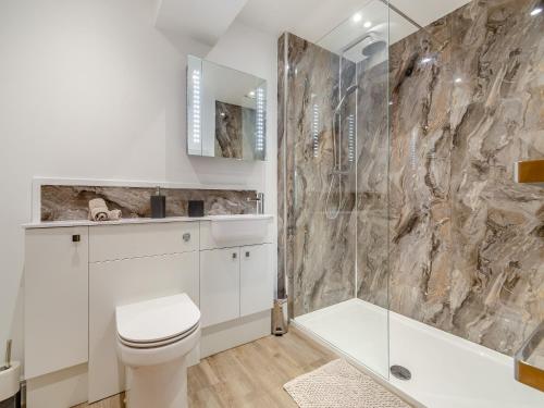 a bathroom with a white toilet and a shower at The Burrow in Pateley Bridge