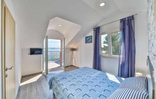 ein Schlafzimmer mit einem blauen Bett und einem Balkon in der Unterkunft 5 Bedroom Amazing Home In Drvenik Mali in Velike Kuknjare