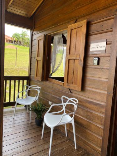 two white chairs sitting on a wooden deck at Hacienda el Jibarito in San Sebastian