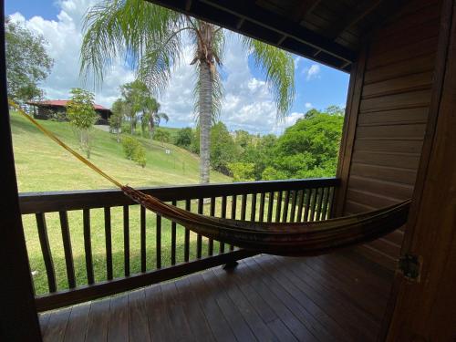 a hammock on a porch with a palm tree at Hacienda el Jibarito in San Sebastian