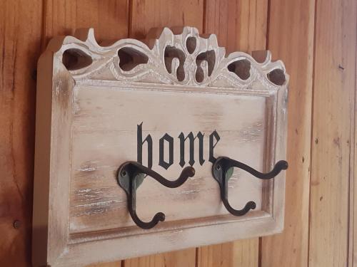 a sign that says home on a wooden wall at Cabañas Puente Negro in Puente Negro