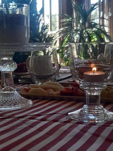 a table with glasses and a candle on a table at Cabañas Puente Negro in Puente Negro