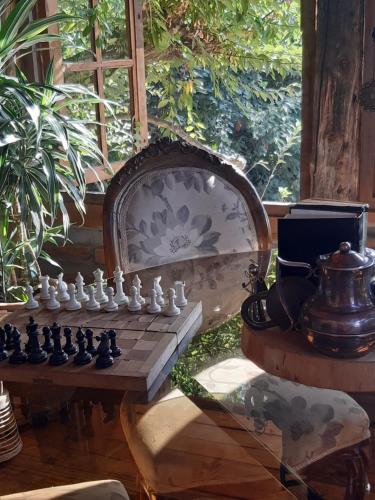 a chess board and a chair with a chessboard and a table at Cabañas Puente Negro in Puente Negro