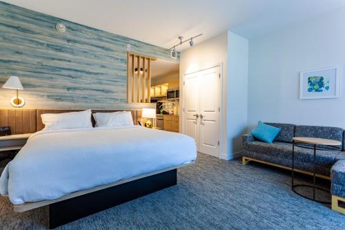 a hotel room with a bed and a couch at TownePlace Suites by Marriott Raleigh - University Area in Raleigh