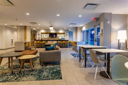 a restaurant with tables and chairs and a bar at TownePlace Suites by Marriott Raleigh - University Area in Raleigh