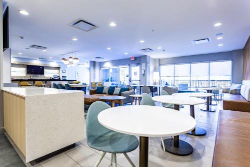a lobby with tables and chairs and a cafeteria at TownePlace Suites by Marriott Raleigh - University Area in Raleigh