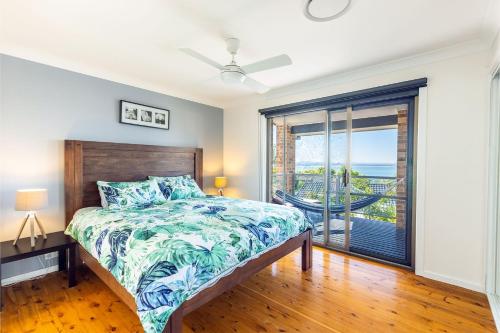 um quarto com uma cama e uma grande janela em Away at Nelson Bay, 29 Wollomi Ave - Water Views, Pet Friendly, Wifi & Aircon em Nelson Bay