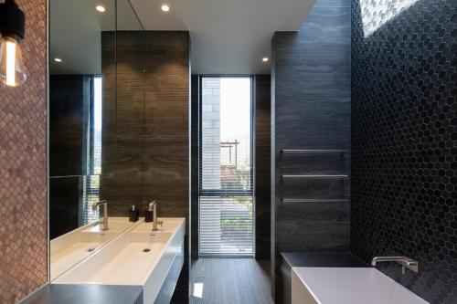 uma casa de banho com 2 lavatórios e uma grande janela em Ivy Box Art Gallery Apartment em Queenstown