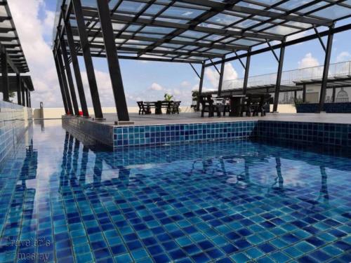 una grande piscina con tavolo da picnic di [FREE WI-FI]Travelers Homestay Sitiawan[6~10Pax]The Venus Apartment a Sitiawan